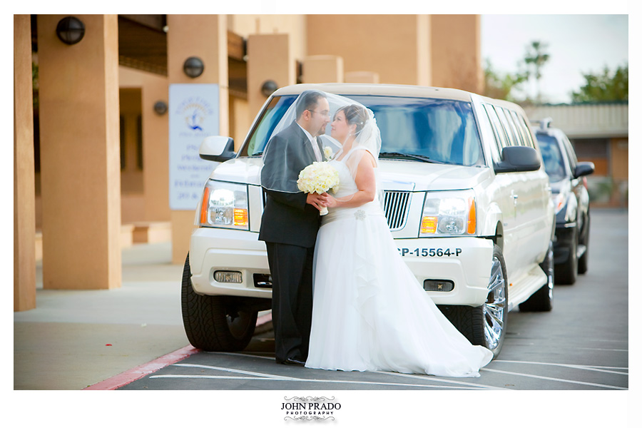 Bride & groom posing infront of limo for photos