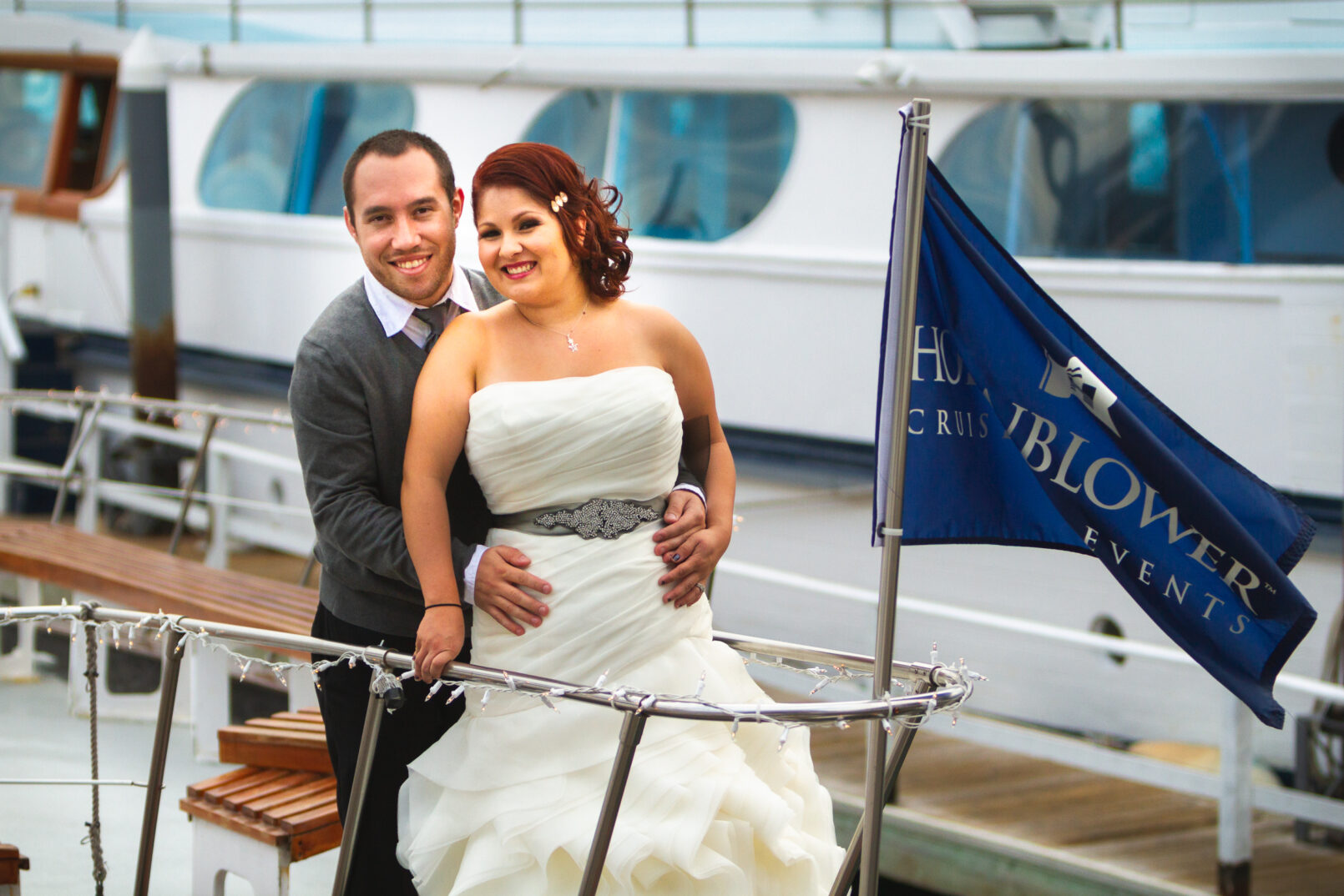 Bride & Groom posing for a photo in Newport harbour
