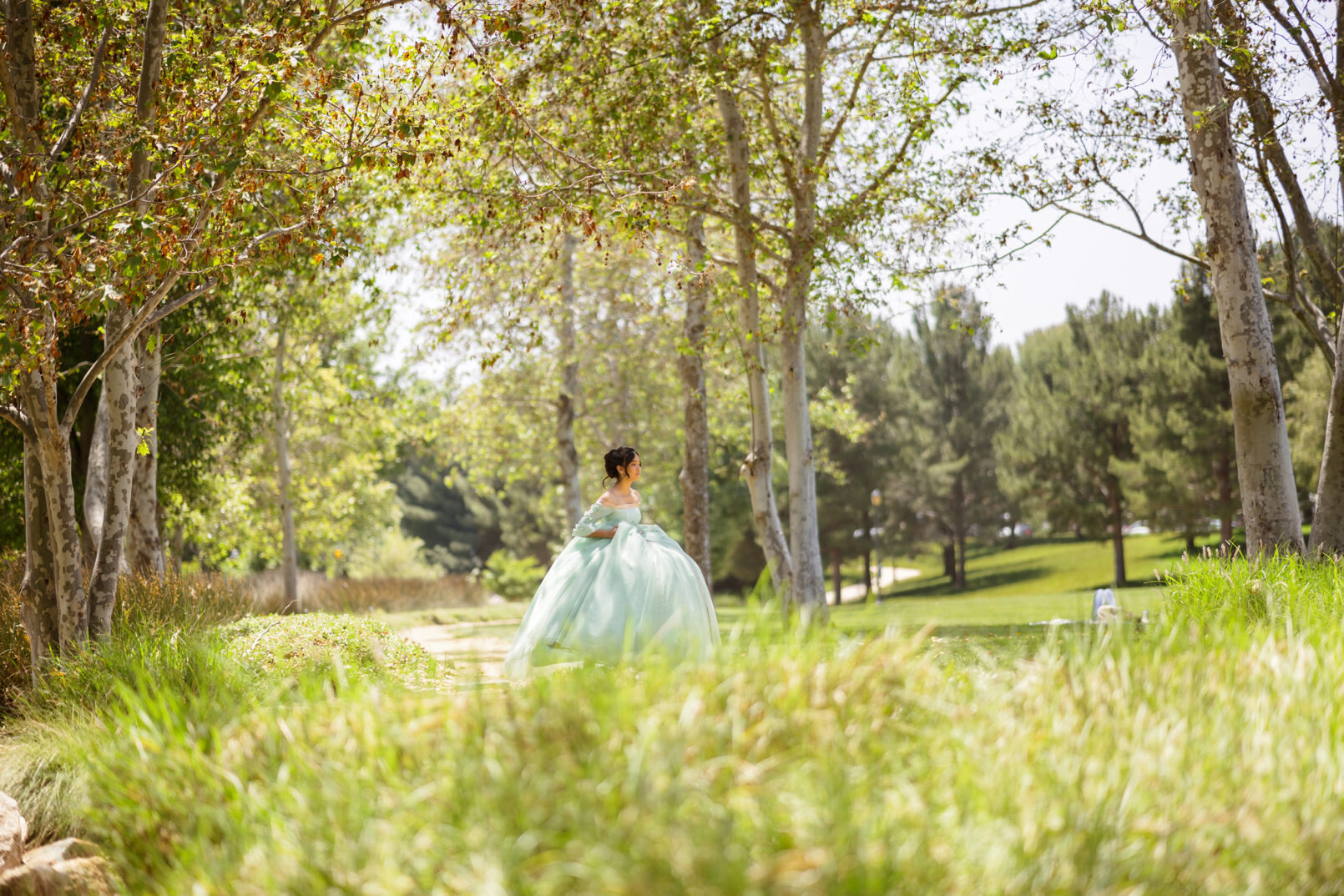 Quinceanera green ballgown dress walking in the park