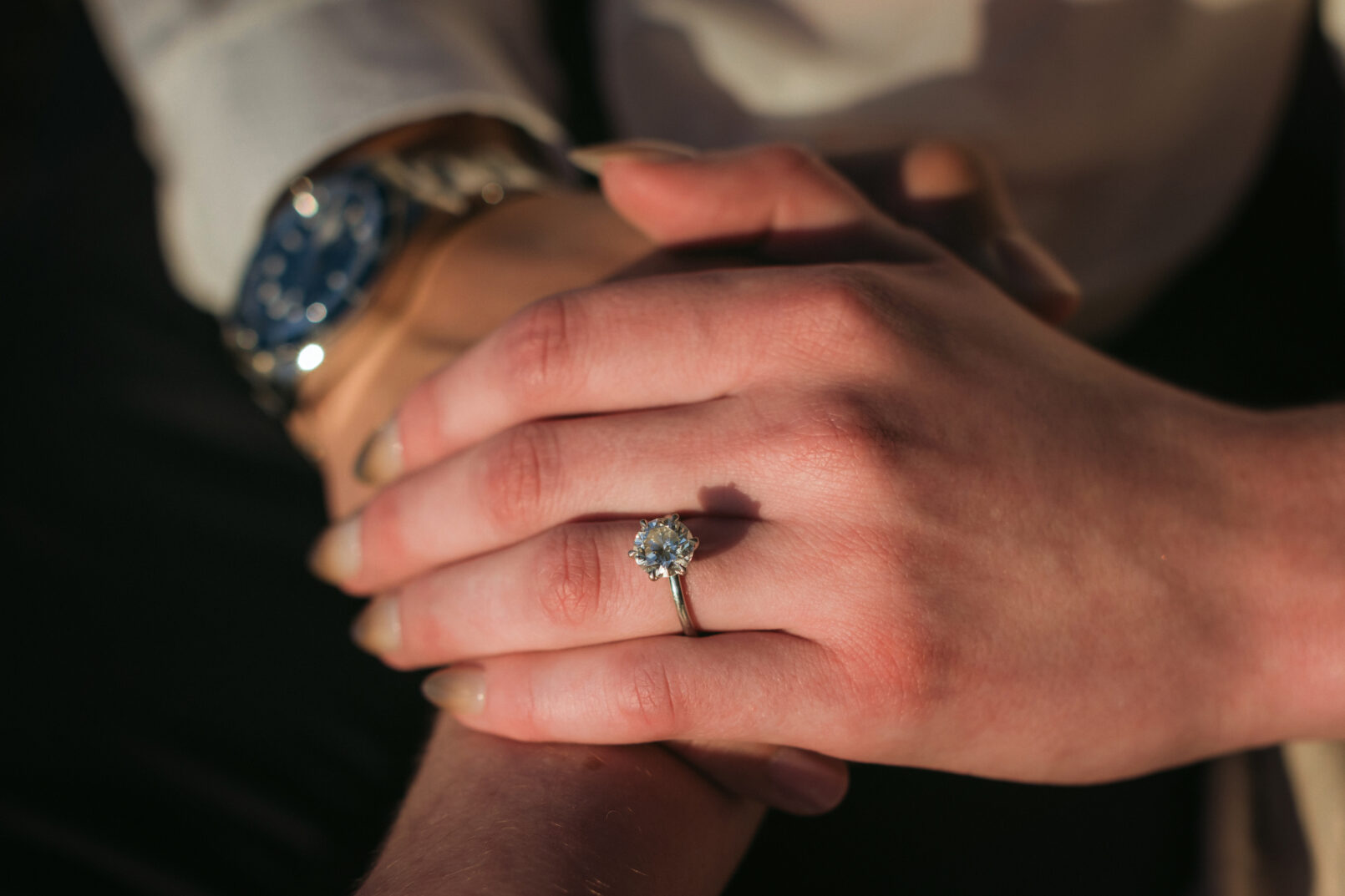 Engaged couple holding rings together
